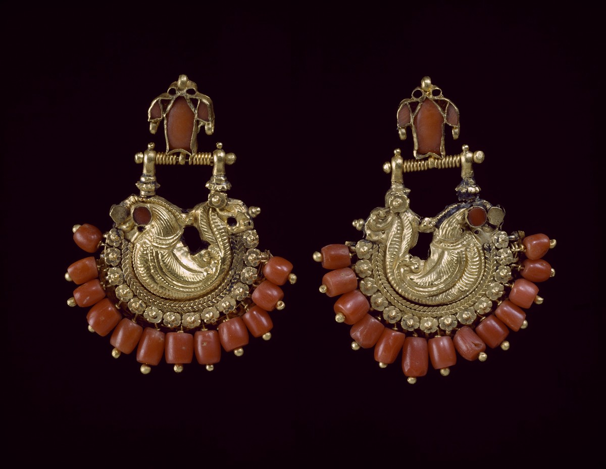 Museo Antonino De Simone, Orecchini Sud India, XX secolo. Gli orecchini si sviluppano intorno ad un ventaglio di grani di Corallo con al centro, sbalzato nell’oro, un pavone