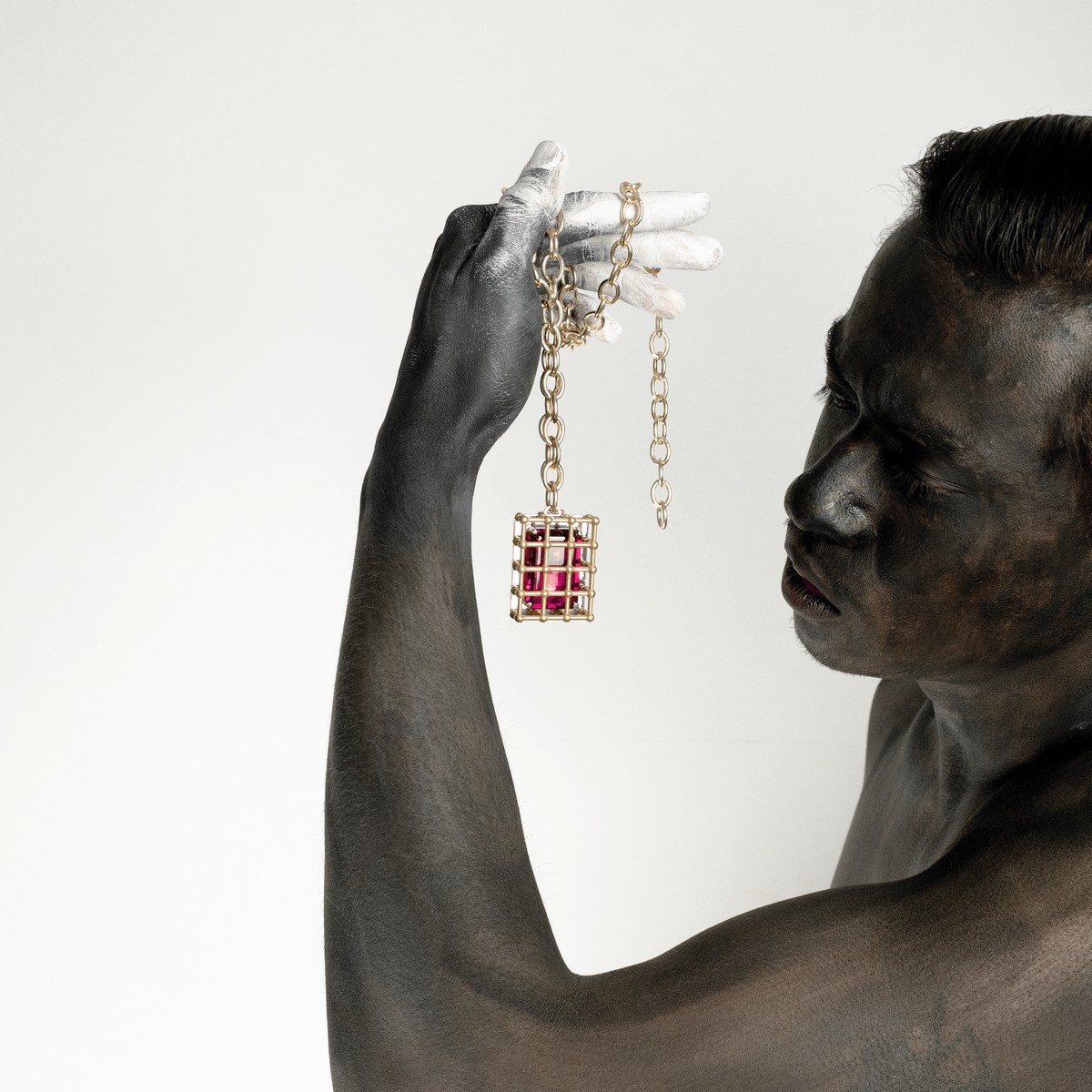 “A stone in a cage” di Chiara Dynis, gabbia in bronzo e argento con corindone rosso, 2018