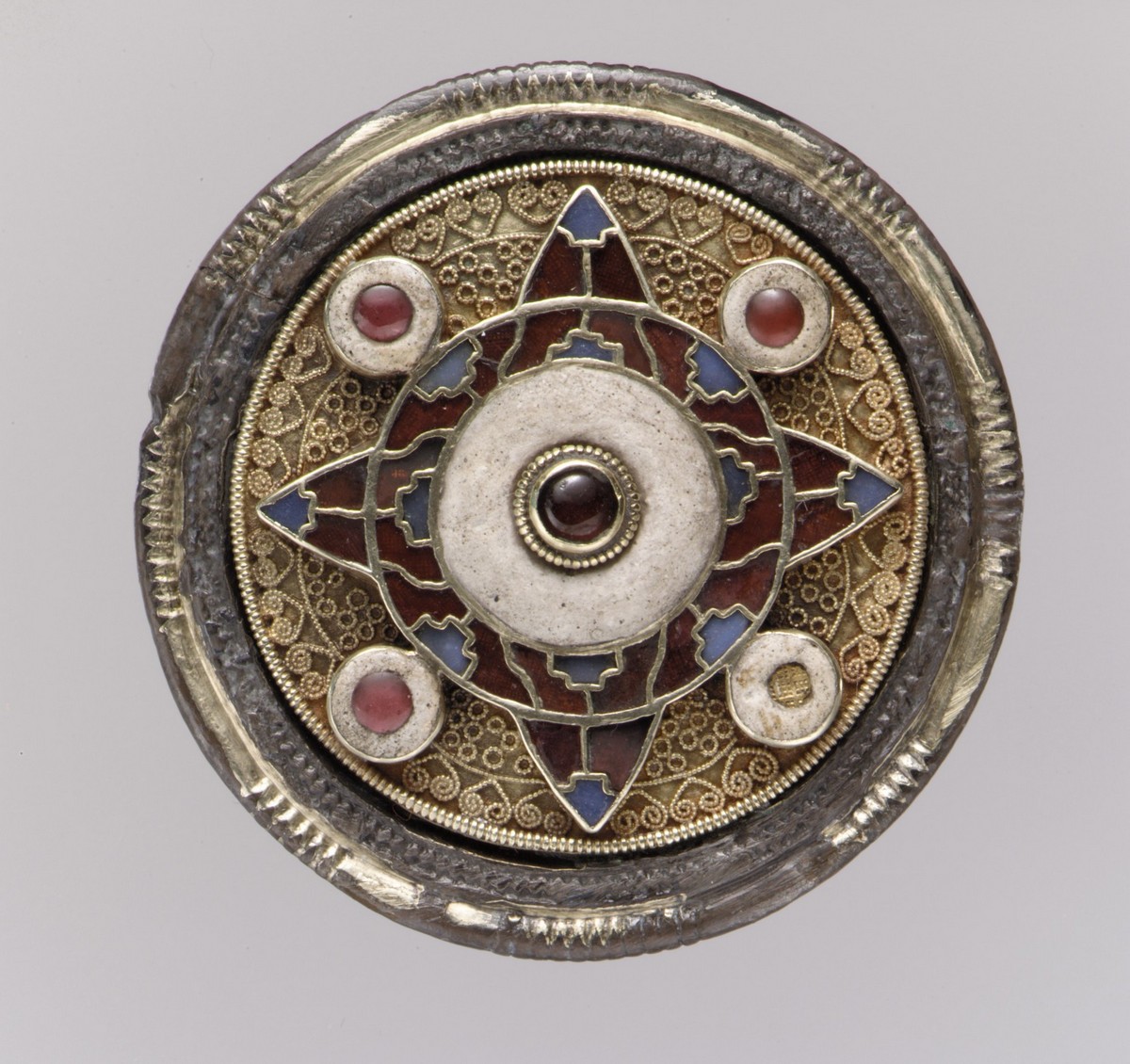 Spilla a disco anglosassone dai colori vivaci (circa 600 d.C.). I motivi in filigrana d’oro e i granati lucidati riflettono l’alta qualità degli oggetti indossati dagli individui dell’epoca