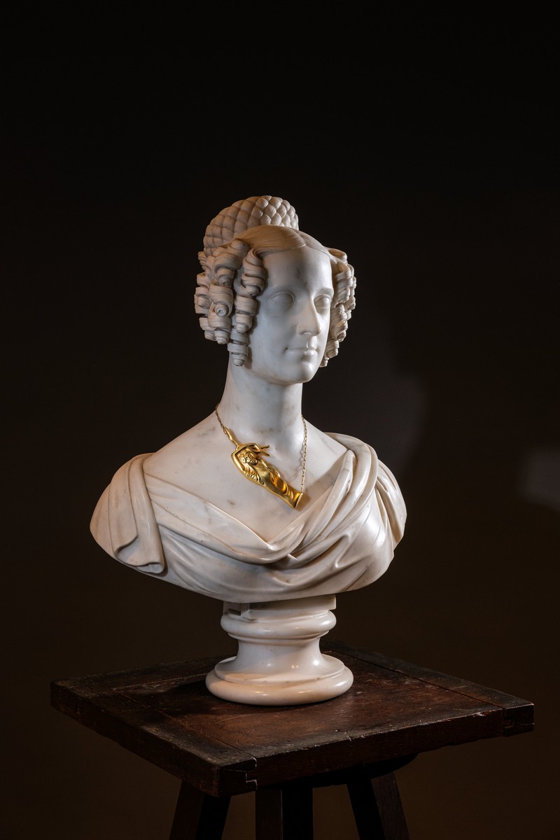 Scultura di giovane donna, accompagnata da una collana di Man Ray