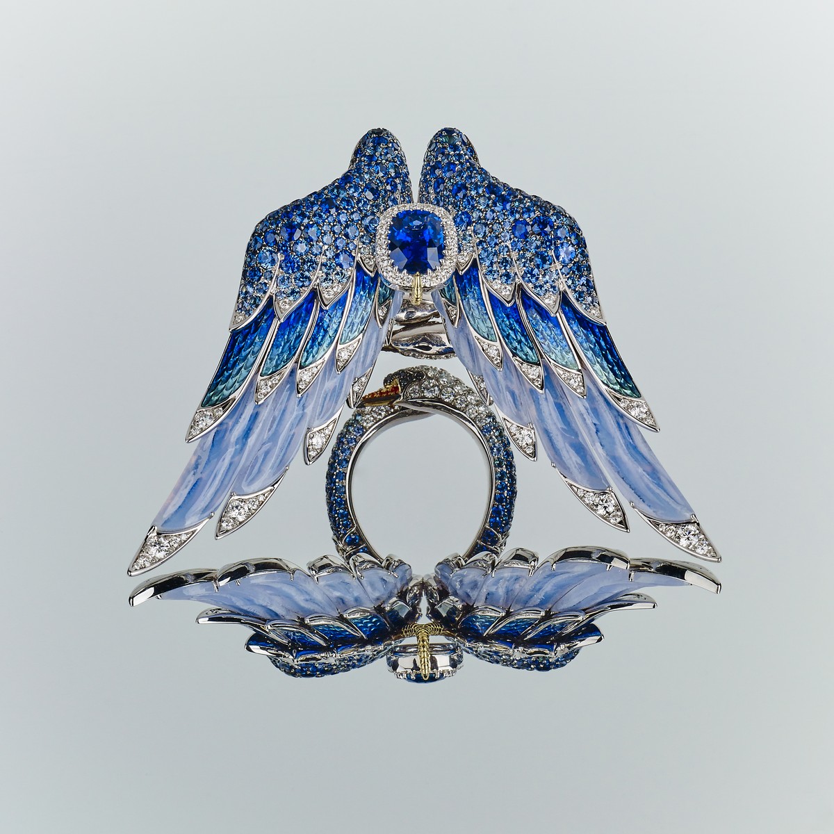 L’anello del cigno simboleggia quattro significati diversi da quattro angolazioni diverse. Come un cigno bianco riflesso nell’acqua azzurra, Chong ha utilizzato zaffiri, smalti, smalti traslucidi e calcedonio venato bluastro sulle piume, combinando diversi blu