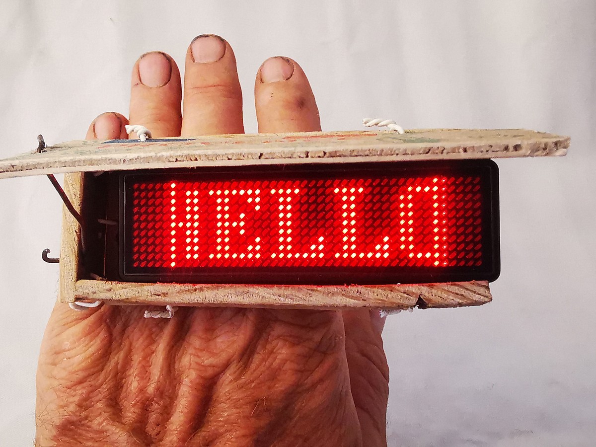 Hello Ring di Willy Van de Velde, plexiglass, acciaio inossidabile, fili elettrici e legno grezzo